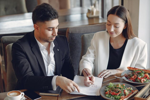 two people talking and pointing at a paper